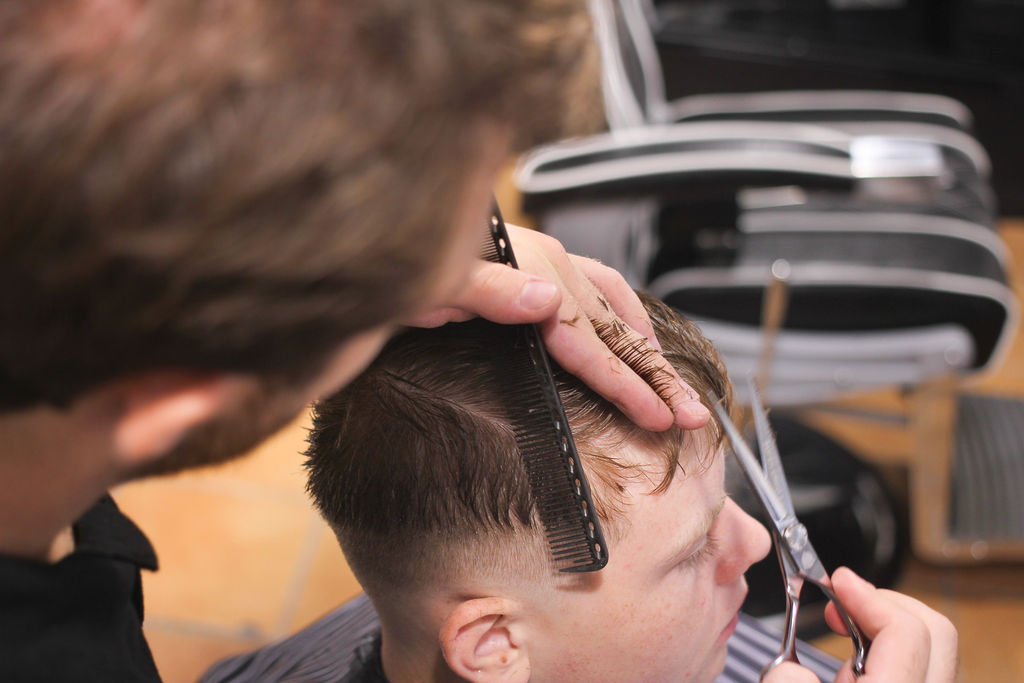 Barber finishing a precision cut with scissors
