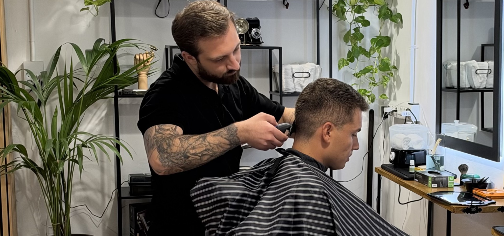 Sergi cutting hair at the Short Cuts Barbershop chair
